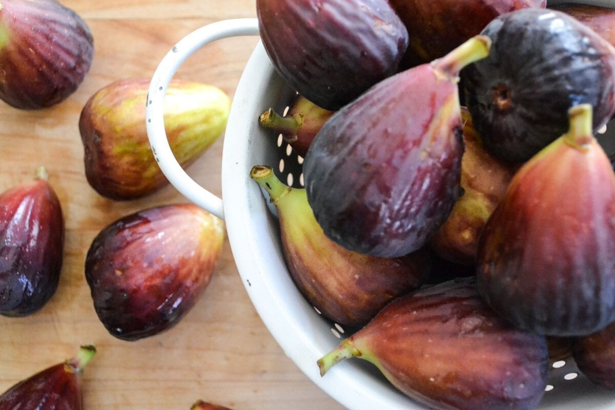 Brown turkey figs in colander and on cutting board.