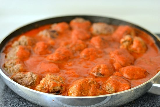 A skillet filled with homemade meatballs simmering in spaghetti sauce.