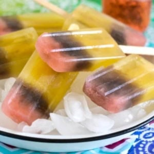 Tri colored ice pops layered on ice.