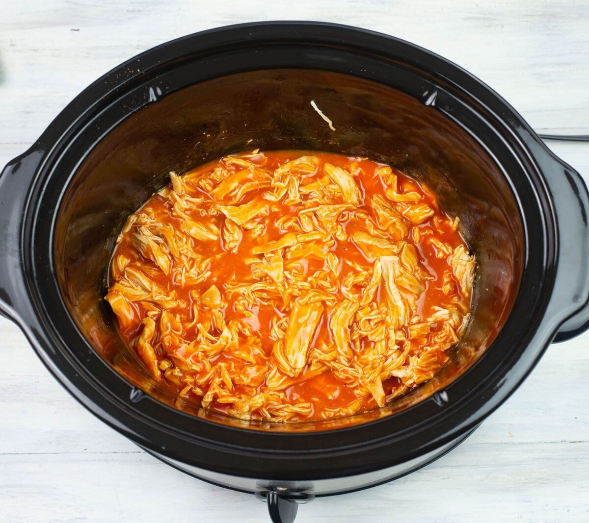 Cooking the crock pot pulled buffalo chicken until thickened.