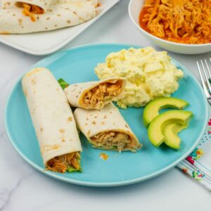 Crock Pot Buffalo Chicken Wraps served with ranch dressing on a dinner plate.
