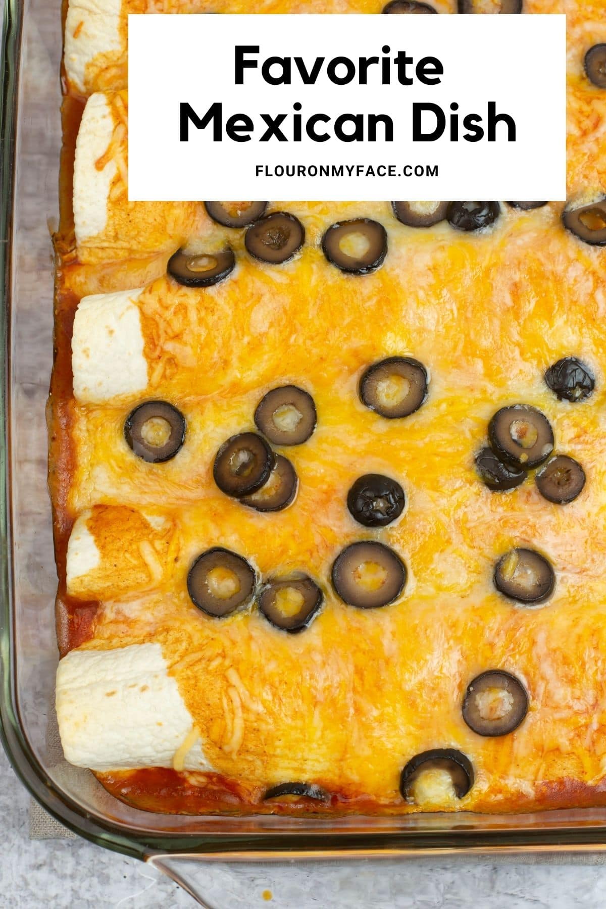Long vertical image of a tray of baked enchiladas.