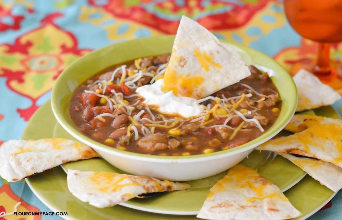 Sausage Chili in a bowl topped with sour cream.