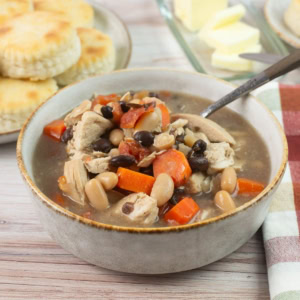 Bowl of Chicken Tomato and Bean Soup with biscuits and butter.