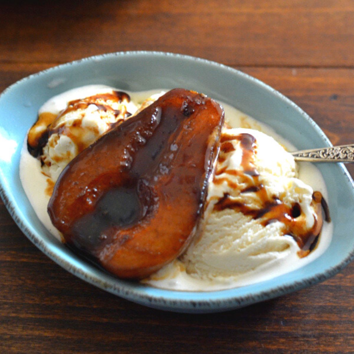 Balsamic Poached Peach served over vanilla ice cream in a bowl.