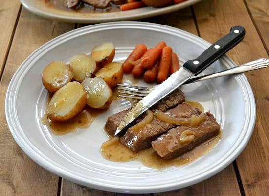 Crock Pot London Broil served with potatoes and carrots on a plate