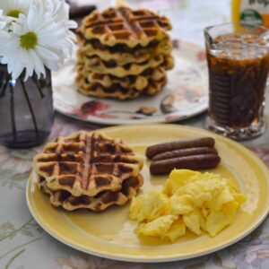 Cinnamon Roll Waffles served with eggs and sausage.