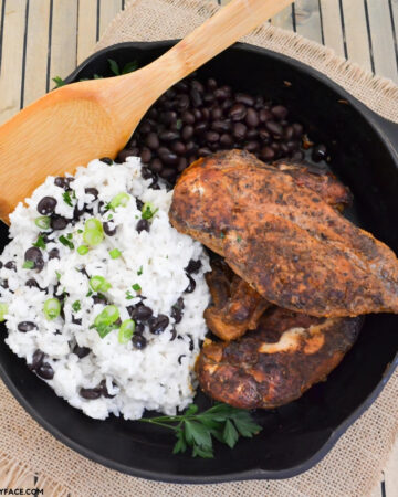 Crock Pot Jamaican Jerk Chicken with coconut rice and black beans served in a cast iron skillet
