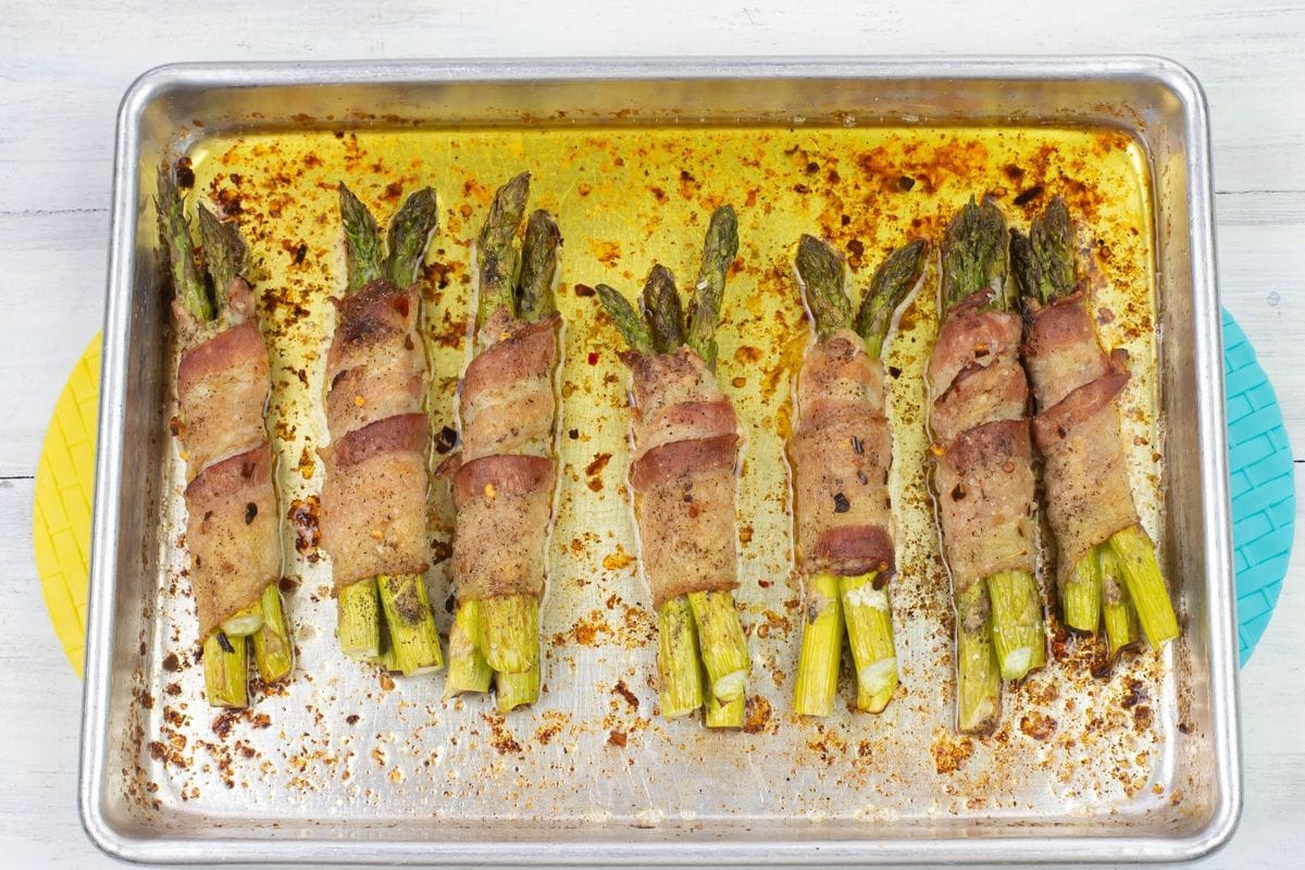 Bacon wrapped bundles on a baking sheet with golden brown bacon.