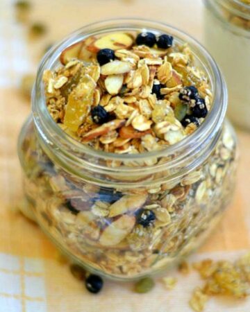 Glass jar filled with homemade pineapple blueberry granola.