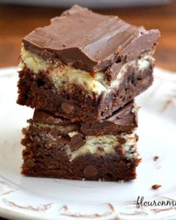 Cheesecake Brownie Bars stacked on a dessert plate.