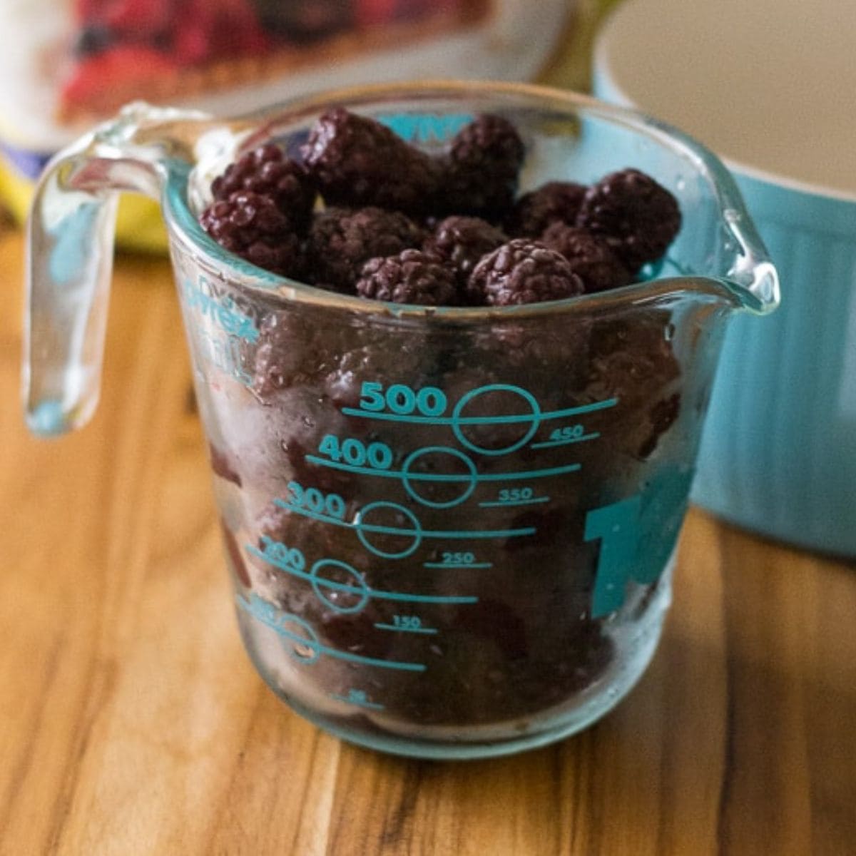 fresh blackberries in a clear measuring cup.