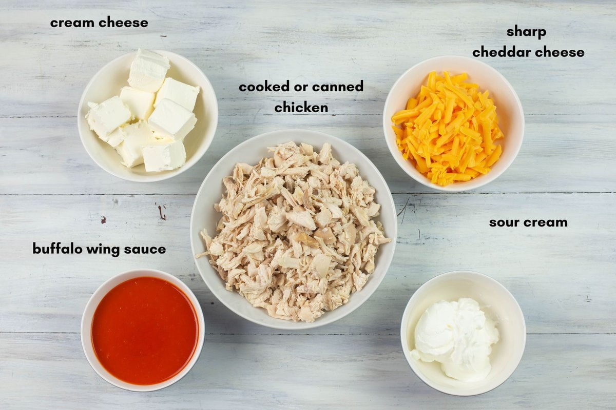 Buffalo chicken dip ingredients in small bowls.