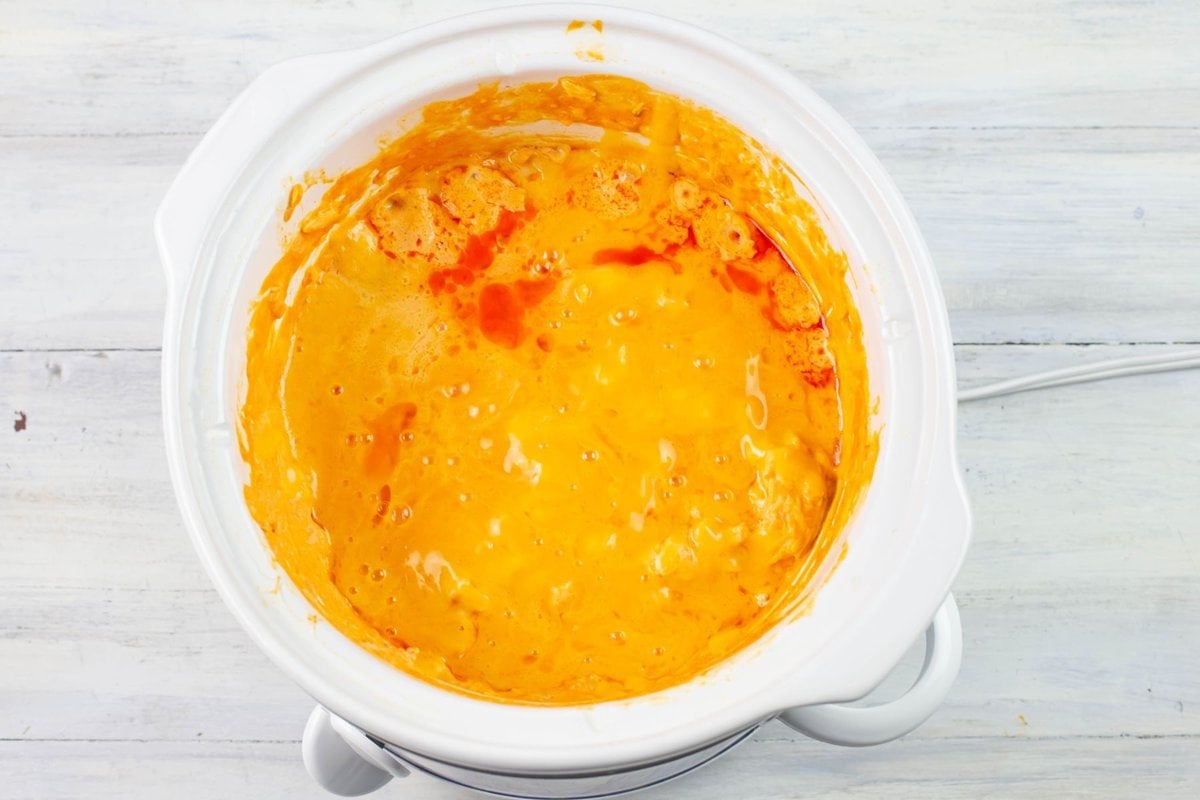 Overhead image of melted cheddar cheese on buffalo chicken dip.