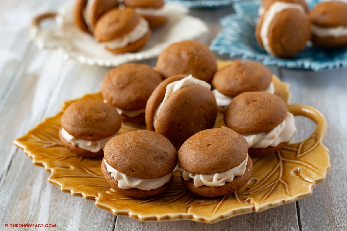 Pumpkin Spice Whoppie Pies piled on a brown fall plate shaped like a leaf