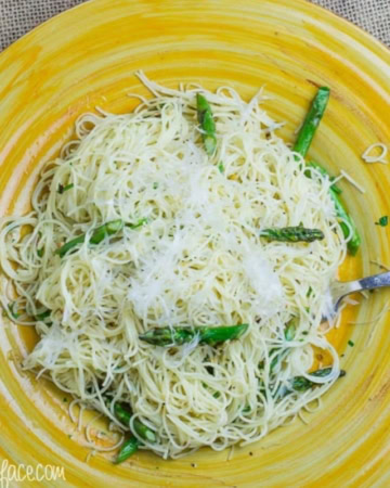 A yellow plate with a serving of Garlic Asparagus Pasta.