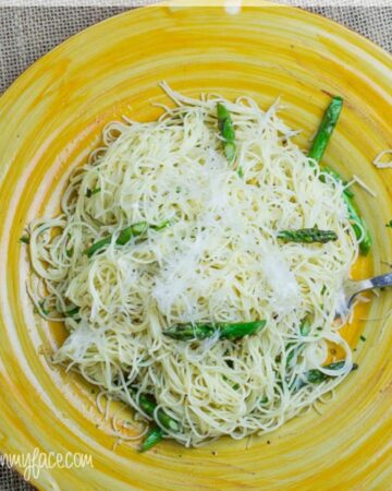 A yellow plate with a serving of Garlic Asparagus Pasta.