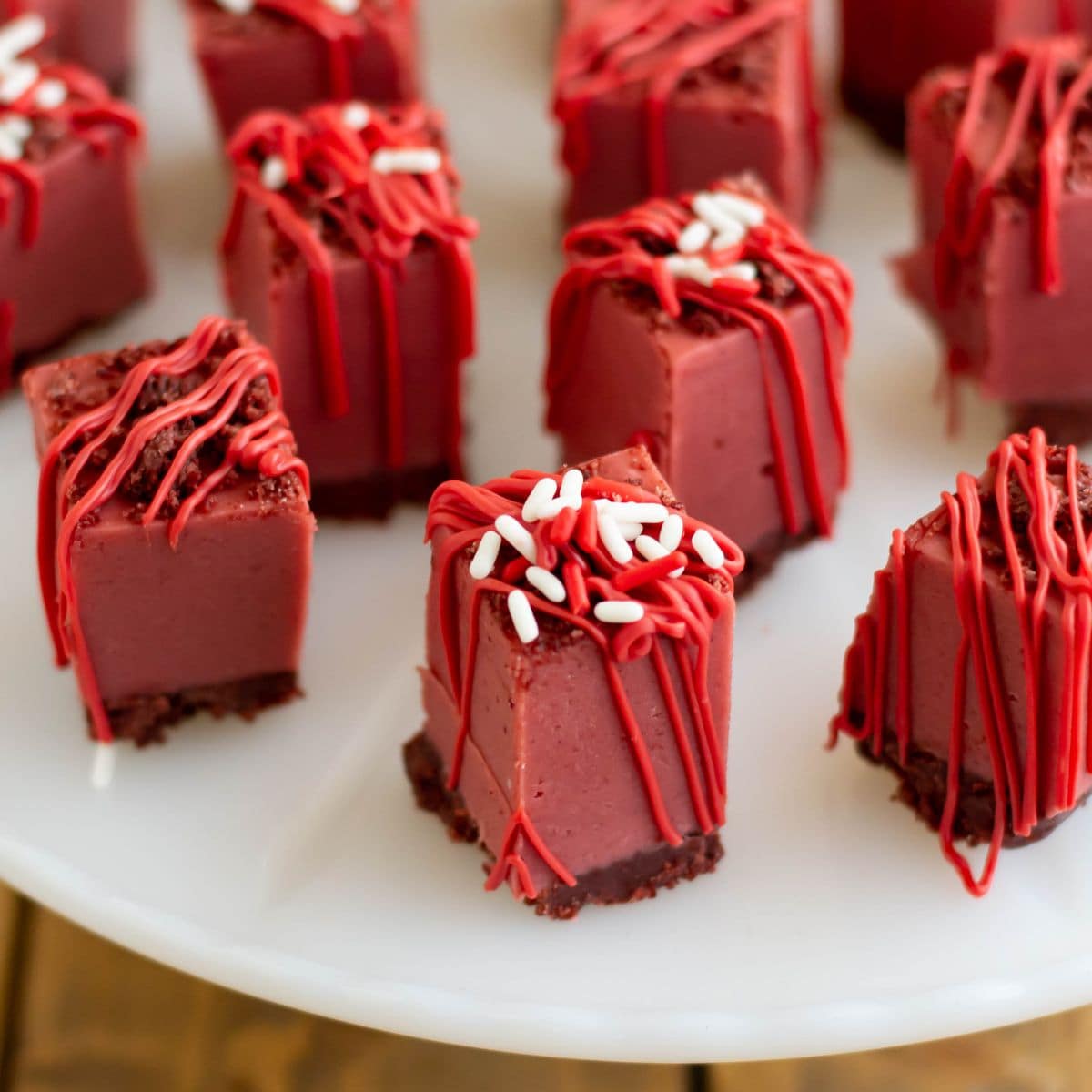 Squares of Red Velvet Fudge on a cake stand.