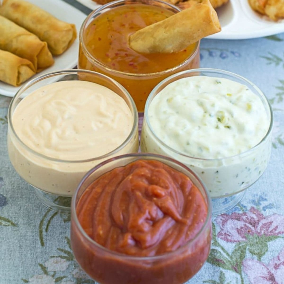 Small bowls filled with 4 varieties of shrimp dip.