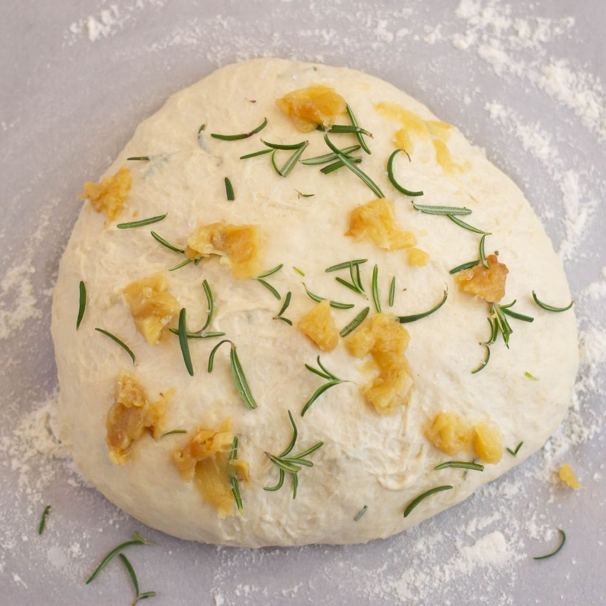 No knead garlic rosemary bread dough covered with fresh rosemary.