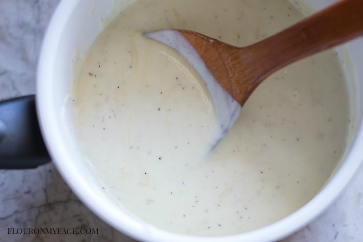 a sauce pan filled with a thick and cheesy sauce recipe. 