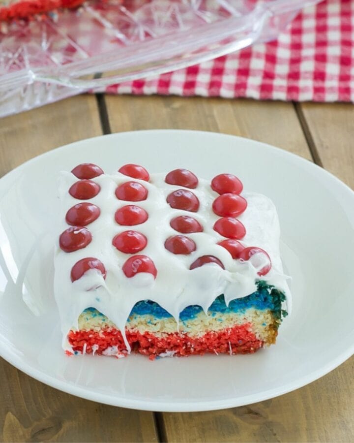 A red white and blue cake bar topped with Skittles on a plate.