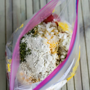 Overhead of open freezer bag with ranch potato ingredients inside.