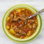 Southwestern pork stew in a bowl with a spoon.
