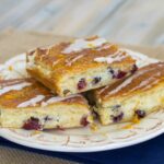 A stack of three cranberry orange crescent bars on a dessert plate.