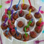 Peach Cranberry Meatballs on mini forks in a round serving platter.