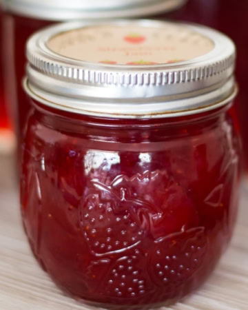 closeup of a canning jar filled with freshly made homemade strawberry jam