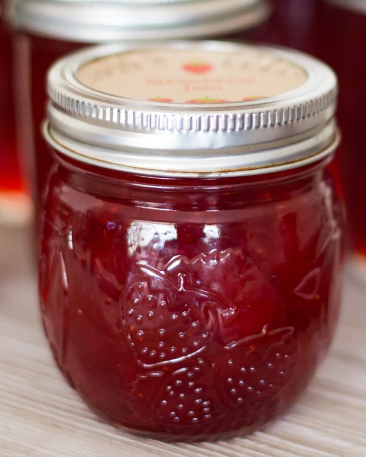 closeup of a canning jar filled with freshly made homemade strawberry jam