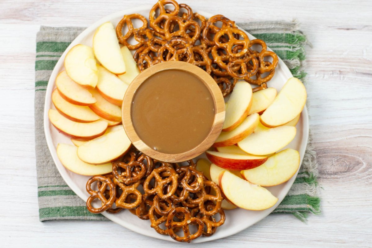 Serving homemade caramel dip with apple slices and pretzels.