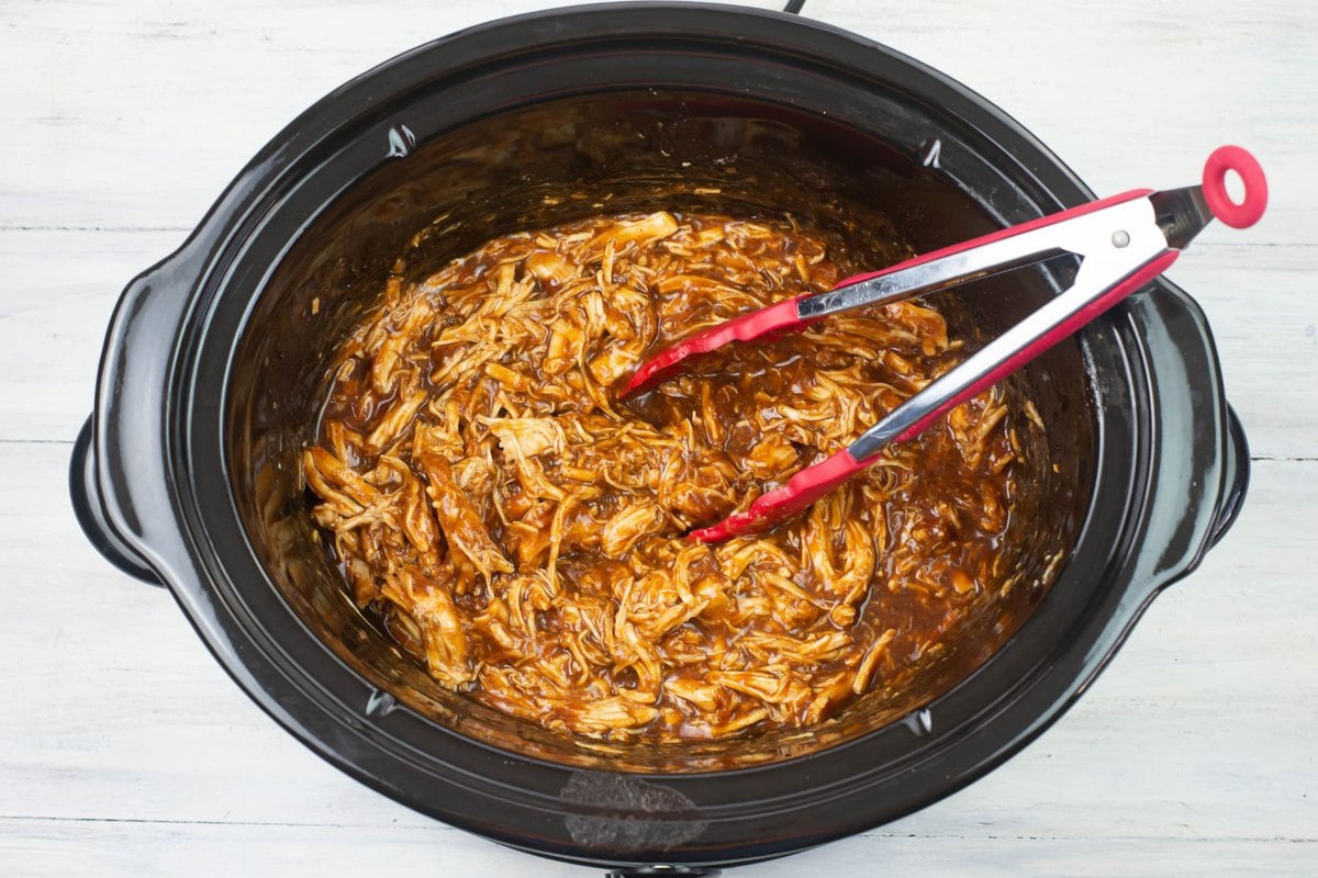 Overhead image showing cooked shredded chicken smothered in cranberry barbecue sauce.