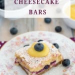 Vertical closeup of blueberry cheese cake dessert bars garnished with lemon curd.