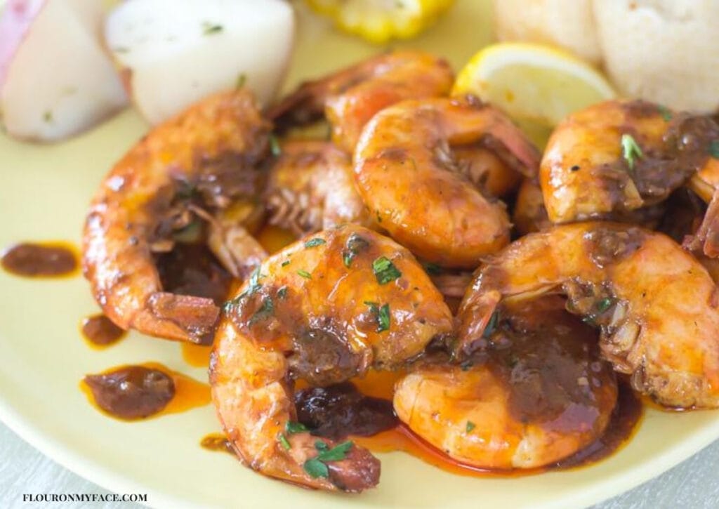 Spicy Barbecue Shrimp drizzled with sauce on a serving platter