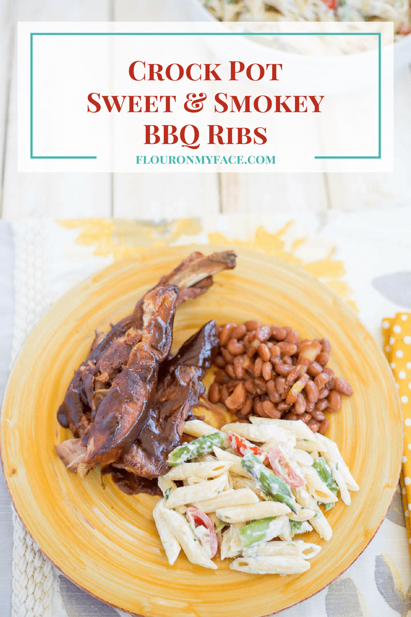 Sweet Smokey Barbecue Ribs on a plate with a serving of baked beans and a pasta salad