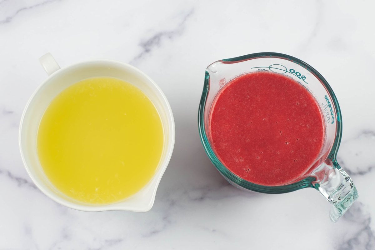 Overhead image of squeezed lemon juice and strawberry puree in measuring cups.