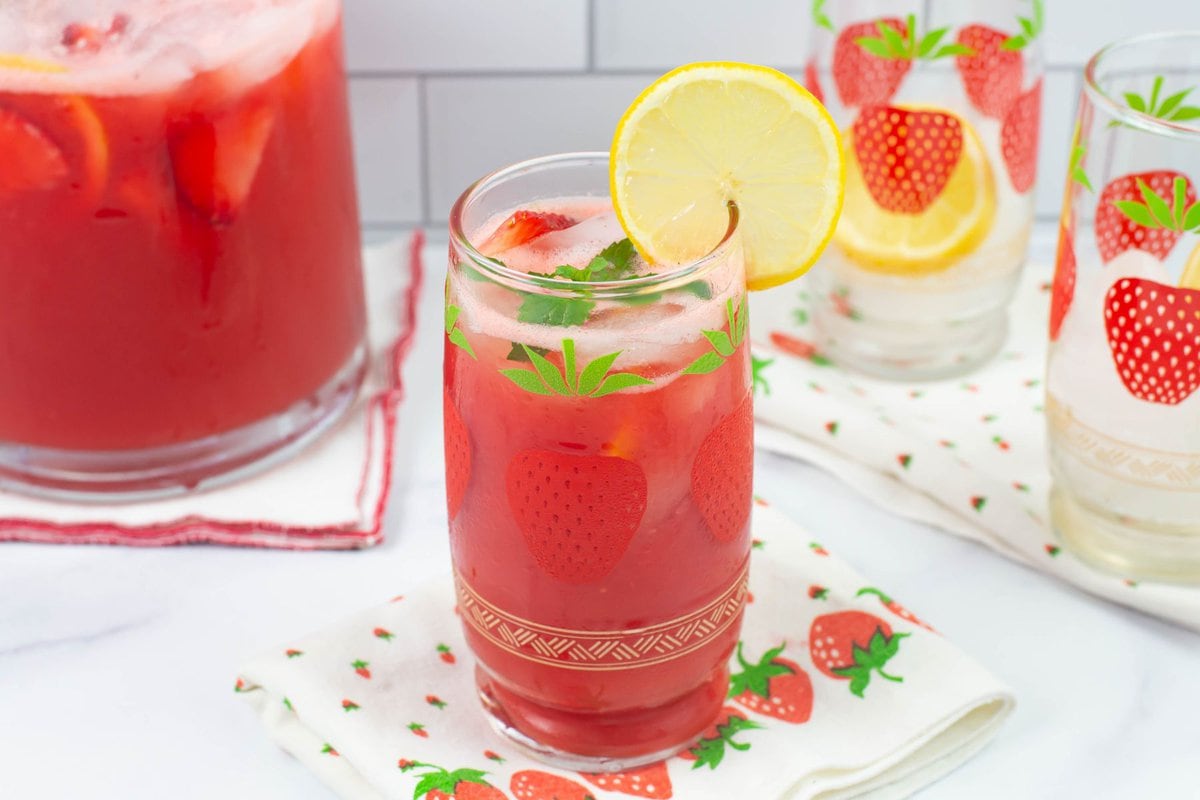 Serving strawberry lemonade in vintage glasses decorated with strawberries. 