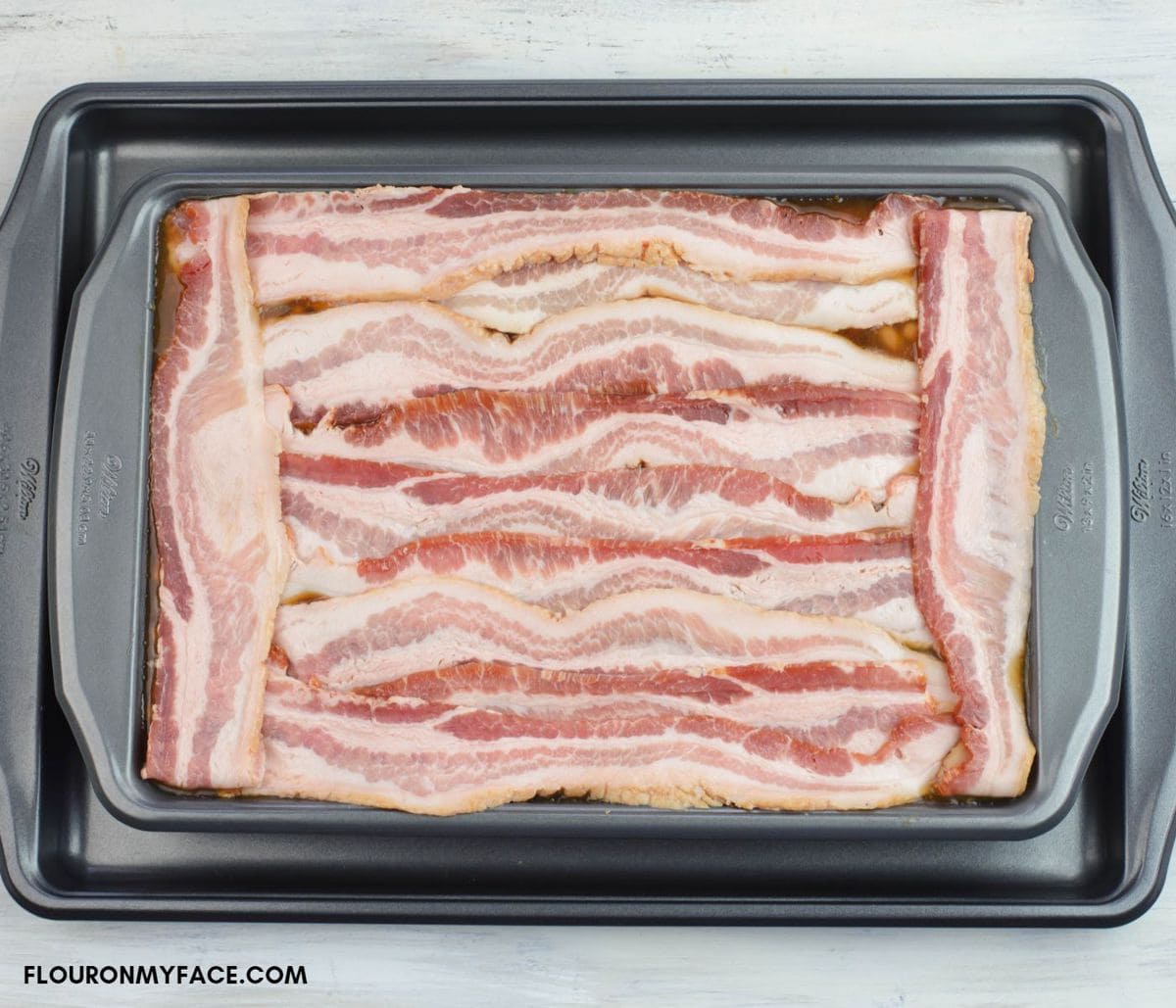 A tray of baled beans with sliced bacon on top.