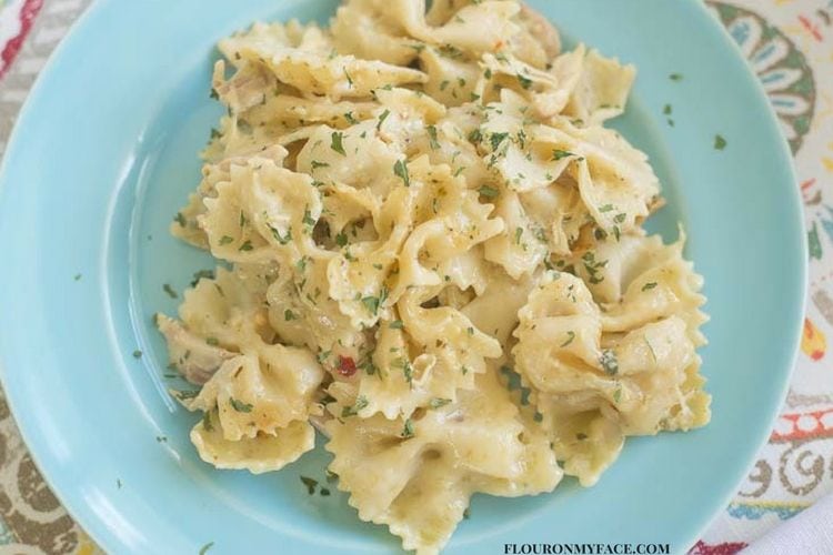 Crock Pot Chicken Alfredo Pasta Casserole recipe on a blue plate via flouronmyface.com