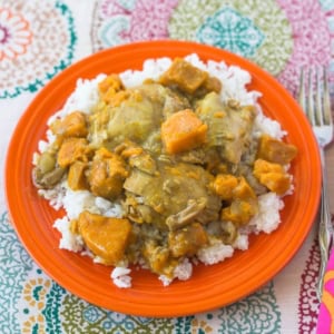 Chicken Curry with sweet potatoes over rice on a plate.