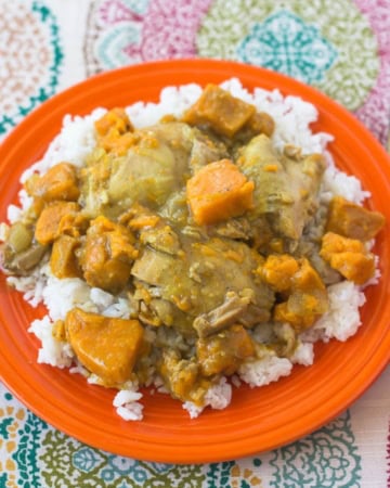 Chicken Curry with sweet potatoes over rice on a plate.