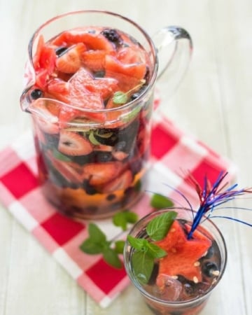 4th of July Sangria recipe served in a glass pitcher so you can see the patriotic colors of Independence Day via flouronmyface.com