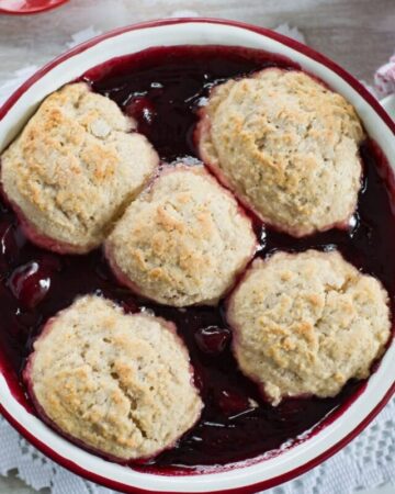 A round pan filled with freshly baked cherry cobbler.