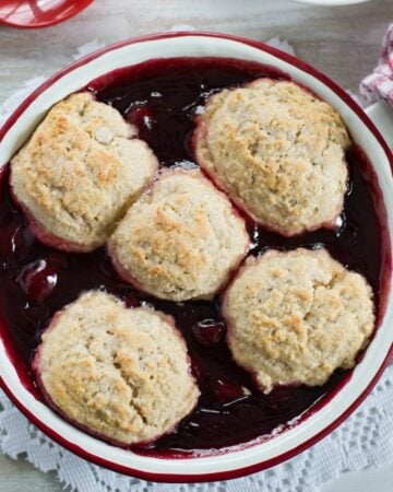 A round pan filled with freshly baked cherry cobbler.