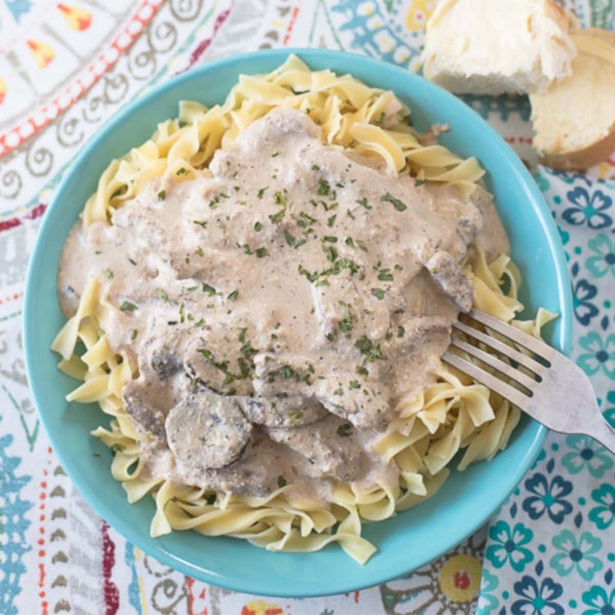 A bowl stuffed with noodles topped with creamy pork stroganoff.  Crock Pot Pork Stroganoff crock pot beef stroganoff
