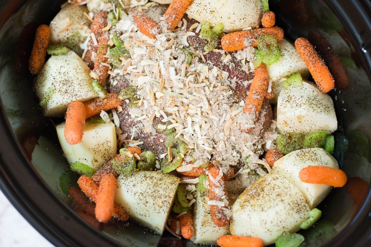 Pot Roast ingredients in a slow cooker before cooking.