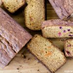 Left over Candied Sweet Potato Bread, loaves sliced on a wooden cutting board to show the pieces of sweet potato throughout the sweet bread recipe.