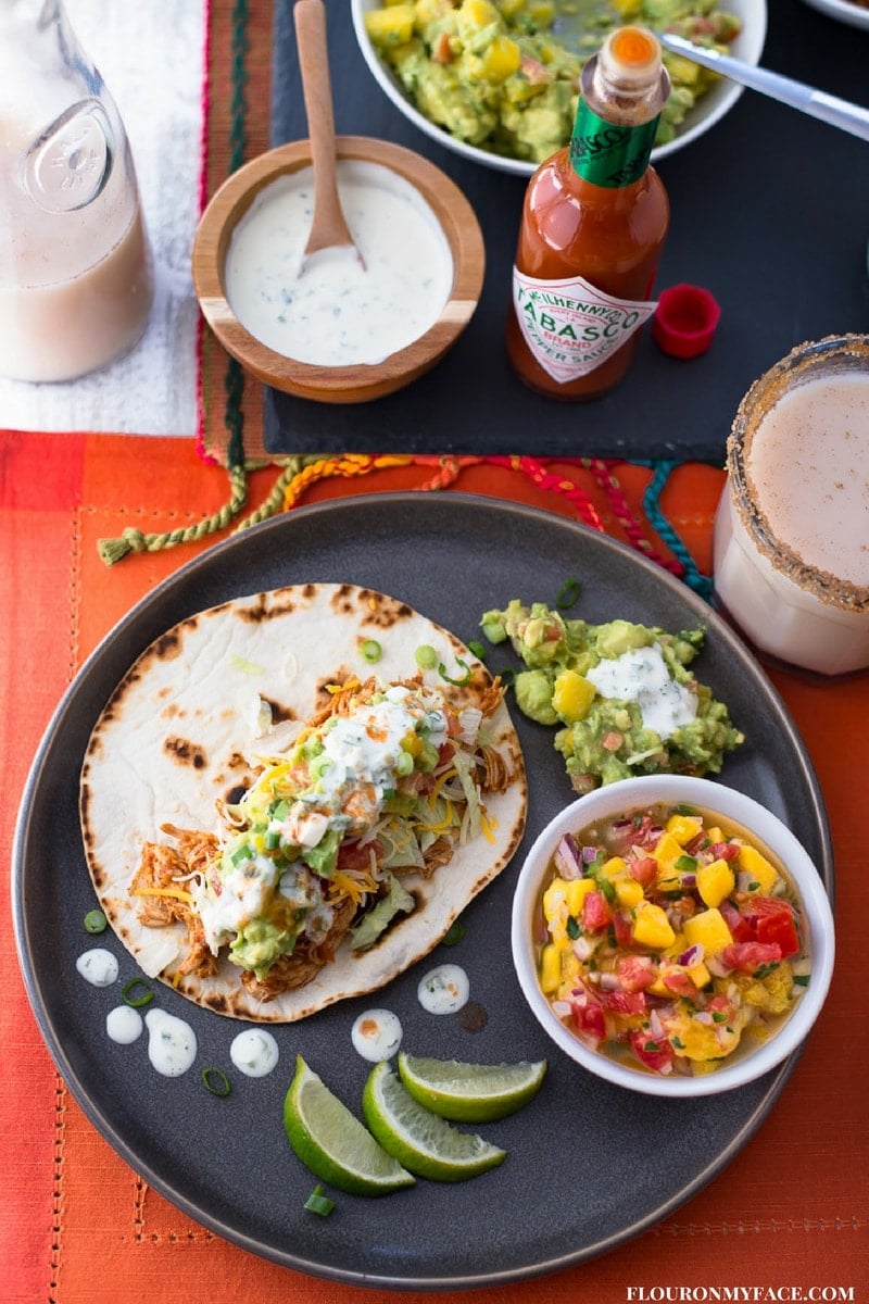 Homemade Guacamole on a Chicken Taco served with Mango Salsa, Jalapeno Sauce and homemade Horchata for the Big Game celebration.